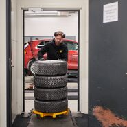 Ein Techniker verstaut gestapelte Winterreifen nach einem Test auf Schneefahrbahn.