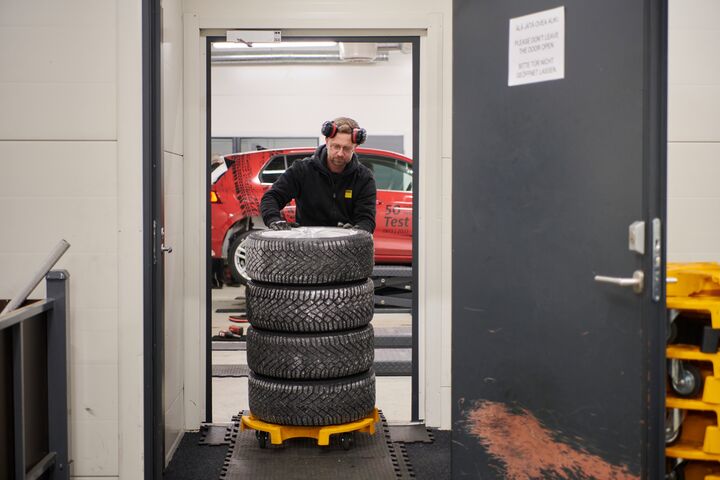 Ein Techniker verstaut gestapelte Winterreifen nach einem Test auf Schneefahrbahn.