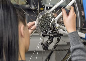 ÖAMTC Technikerin überprüft die Gangschaltung am Hinterrad