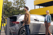 Zwei Personen, die ein Elektroauto an einer ÖAMTC ePower-Ladesäule anschließen, um den Akku aufzuladen.