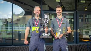 2 männliche Personen halten einen Siegerpokal