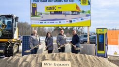 Gerhard Prantner, Alexandra Weidl, Oliver Krupitza und Christian Haberhauer beim Spatenstich für den neuen ÖAMTC Stützpunkt Amstetten auf der Baustelle mit einer Bautafel und Bagger als Hintergrundkulisse