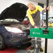 Man sieht einen ÖAMTC-Techniker, der am Stützpunkt die Einstellung der Scheinwerfer eines Autos überprüft