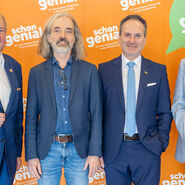 Vier Herren im Anzug stehen nebeneinander