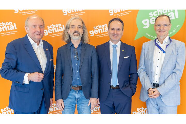 Vier Herren im Anzug stehen nebeneinander