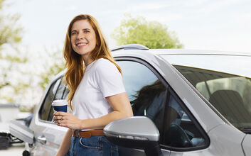 Eine Dame steht vor neben einem Auto vor einer Zapfsäule