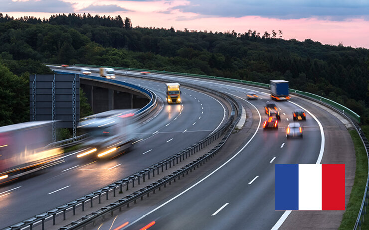 Eine Autobahn mit fahrenden Autos in der Dämmerung in Frankreich