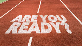 Orangefarbene Laufbahn eines Sportplatzes mit weißem Schriftzug 'Are you Ready?' darauf.