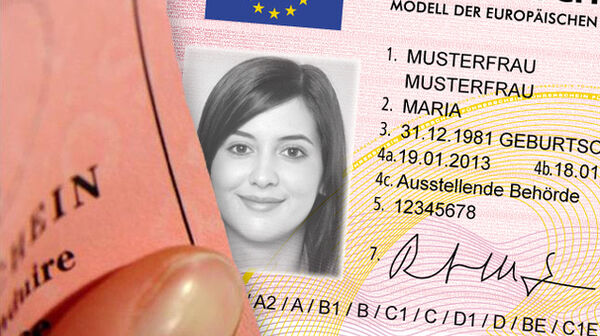 Der Ausschnitt eines rosa Führerscheins im Scheckkartenformat. In der Mitte ist ein Foto einer Frau mit langen Haaren in schwarz-weiß. Rechts neben dem Foto der Frau stehen ihre persönlichen Informationen am Führerschein.