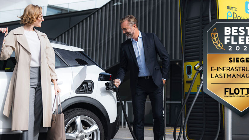 Eine Frau und ein Mann stehen vor einem E-Auto und der Mann hält das Ladekabel in der Hand. Abzeichen Best4Fleet Award.