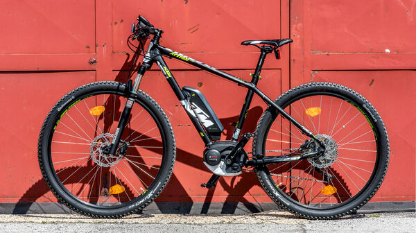E-Bike der Marke KTM steht vor rotem Tor.