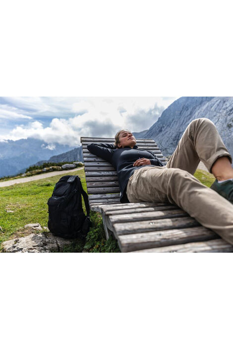 Person liegt auf einer Holzliege in den Bergen. Der Rucksack der Person wurde durch das Combiflex Kabelschloss an der Liege befestigt.