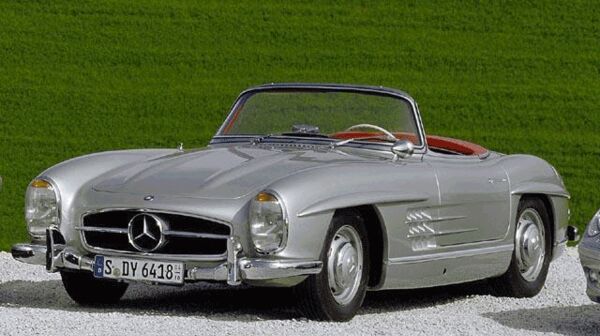 Ein Mercedes Cabriolet steht in einer geschotterten Einfahrt, umgeben von grünem Gras.