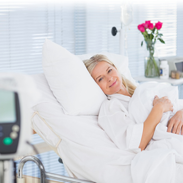 lächelnde Frau in Spitalsbett