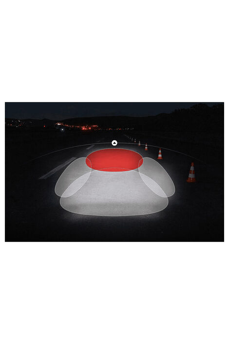 Eine Straße bei Nacht. Rechts stehen der Straße entlang aufgereiht einige Verkehrshütchen, von denen einige angeleuchtet werden. In der Mitte des Bildes sind vier überlappende Ovale. Alle leuchten weiß, abgesehen vom oberen, welches rot leuchtet.