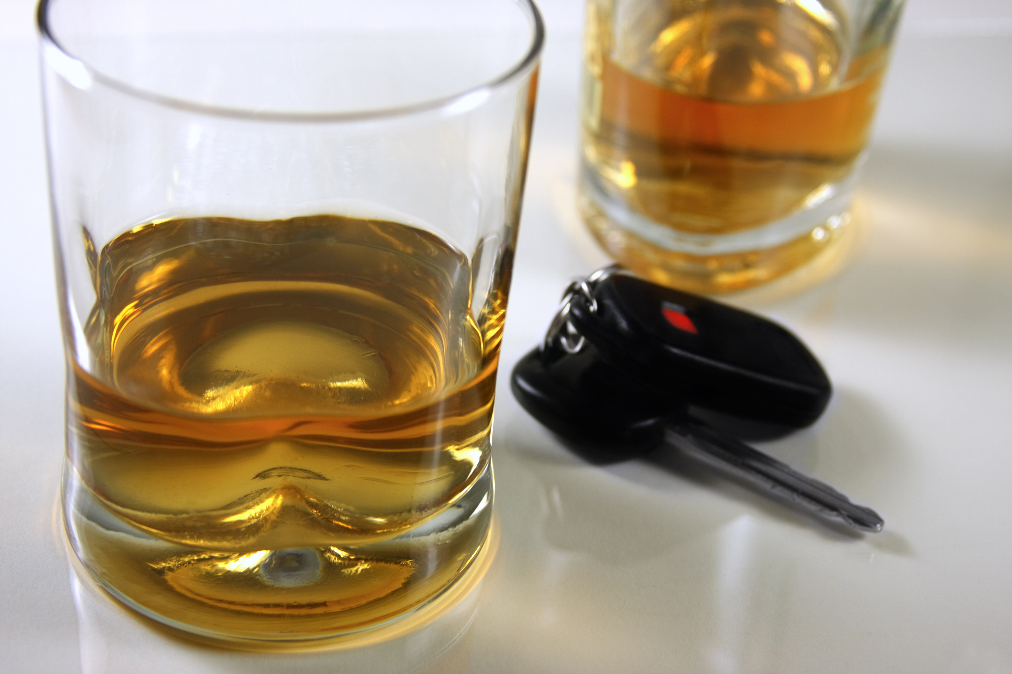 Zwei Gläser mit hochprozentigem Alkohol, daneben liegt ein Autoschlüssel.
