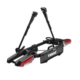 Schwarzer Fahrradträger mit weißer Aufschrift Thule und roten Rücklichter.