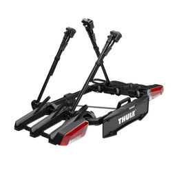 Schwarzer Fahrradträger mit weißer Aufschrift Thule und roten Rücklichter.