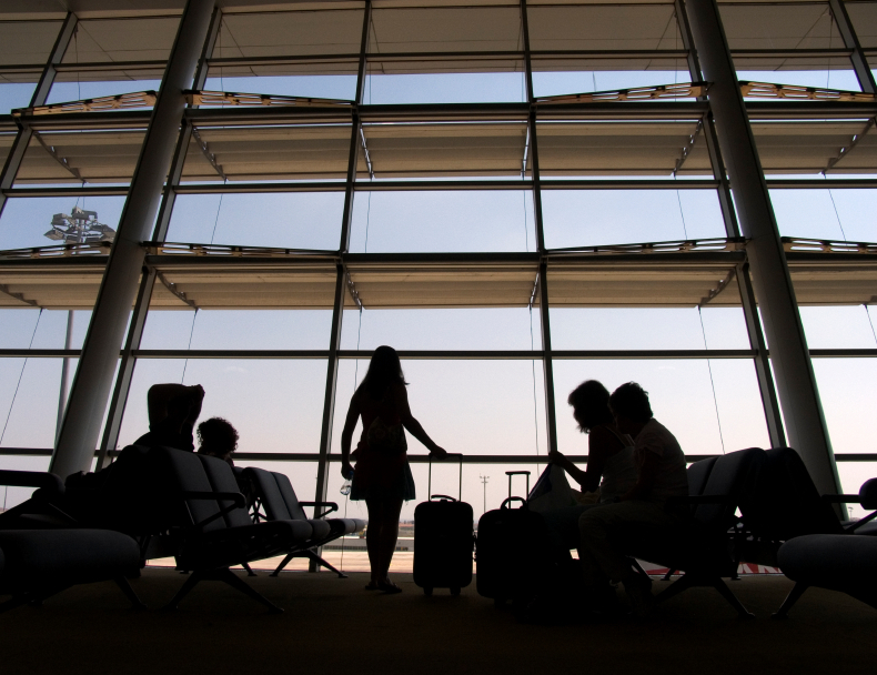 Passagiere warten in der Abflughalle eines Flughafens auf Informationen zu ihrem annullierten Flug