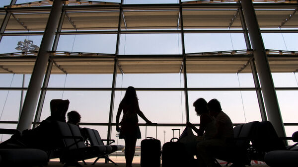 Passagiere warten in der Abflughalle eines Flughafens auf Informationen zu ihrem annullierten Flug
