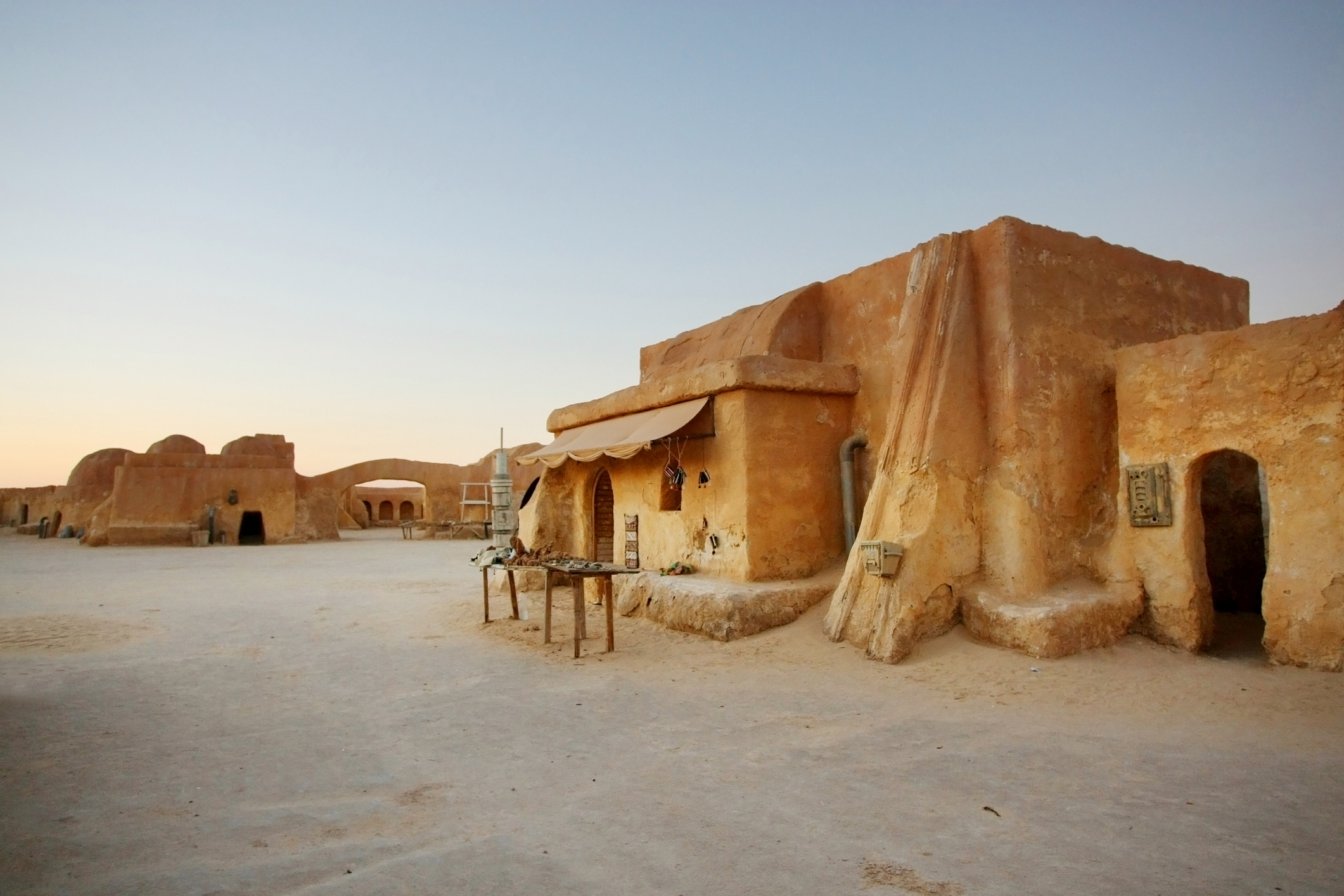 Panoramablick auf Ong Jemel bei Tozeur in Tunesien mit traditionellen Häusern und dem Sahara-Wüstensand im Hintergrund