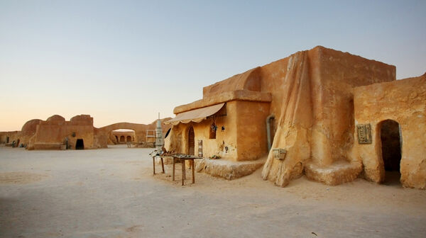 Panoramablick auf Ong Jemel bei Tozeur in Tunesien mit traditionellen Häusern und dem Sahara-Wüstensand im Hintergrund