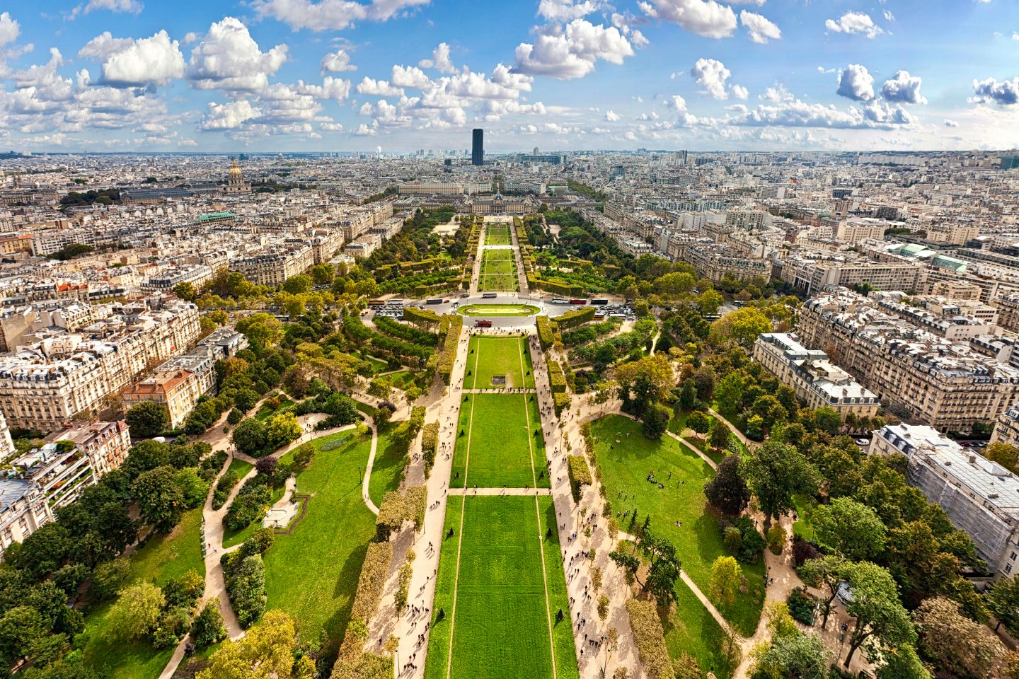 Luftaufnahme des Champ de Mars in Paris mit gepflegten Grünflächen und Wegen, umgeben von der Stadtlandschaft