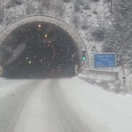 Schneefall vor einem Tunnel auf einer Schnellstraße