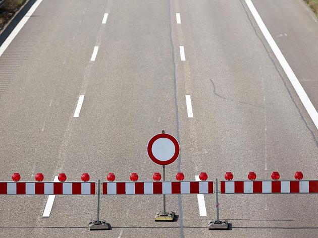 Drei Fahrstreifen einer Autobahn mit einer Absperrung und einem "gesperrt" Verkehrszeichen.