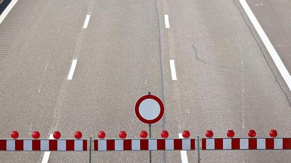 Drei Fahrstreifen einer Autobahn mit einer Absperrung und einem "gesperrt" Verkehrszeichen.