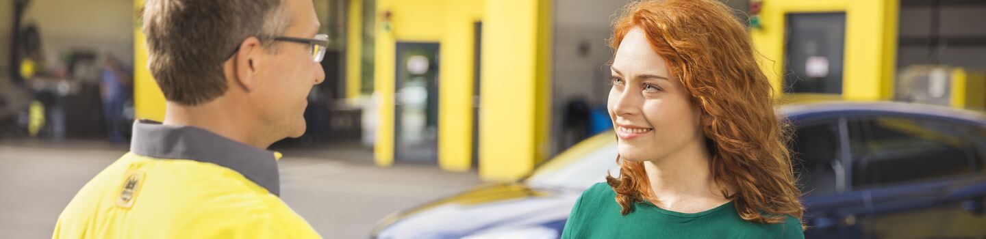 ÖAMTC Techniker übergibt einem weiblichen Mitglied einen Fahrzeugschlüssel