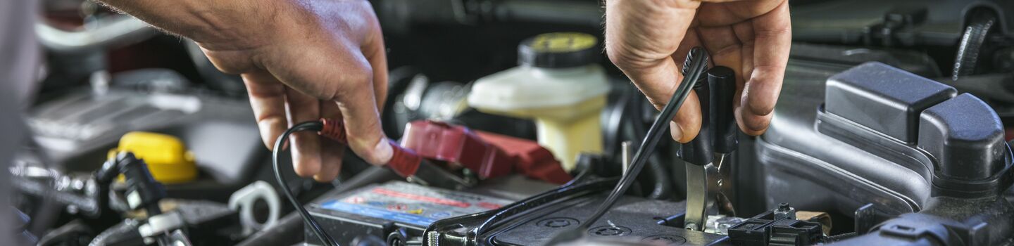ÖAMTC Techniker überprüft eine Autobatterie