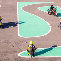 Mehrere Motorradfahrer absolvieren einen Motorrad-Parcours mit engen Kurven auf einem Trainingsplatz