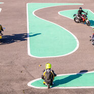 Mehrere Motorradfahrer absolvieren einen Motorrad-Parcours mit engen Kurven auf einem Trainingsplatz