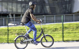 Eine junge Frau übt auf einem Mini-Fahrrad das Radfahren.