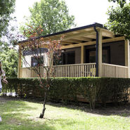 Das Bild zeigt ein Mobilheim auf einem Campingplatz. Links im Bild läuft ein Kind.