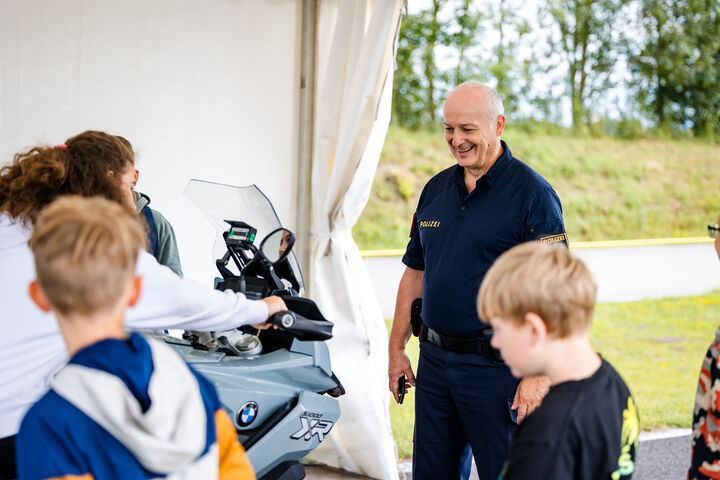 Polizist erklärt Kindern ein Motorrad