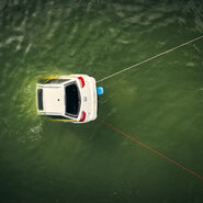 Ein weißes Testfahrzeug ist im Wasser halb versunken von oben zu sehen