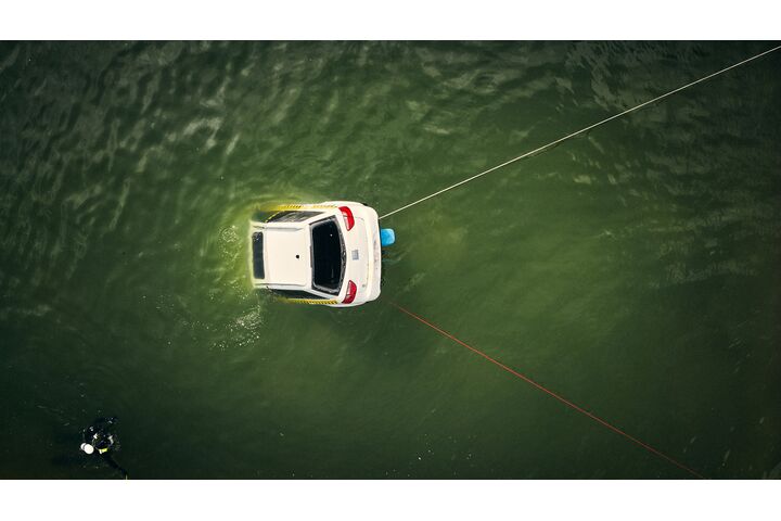 Ein weißes Testfahrzeug ist im Wasser halb versunken von oben zu sehen