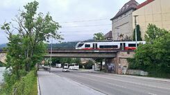 Blick auf die Eisenbahnbrücke bei der Rauchmühle mit vorbeifahrender Schnellbahn