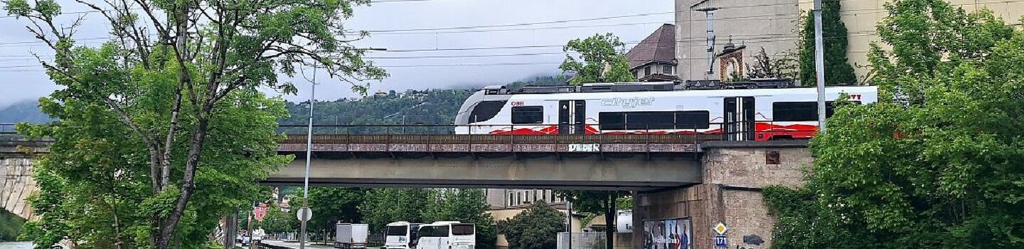 Blick auf die Eisenbahnbrücke bei der Rauchmühle mit vorbeifahrender Schnellbahn