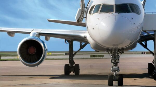 Ein großes silbernes Flugzeug auf einer Start-und Landebahn am Flughafen.