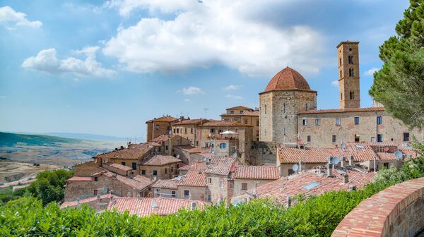 Panoramablick auf die mittelalterliche Altstadt von Volterra in der Toskana, umgeben von sanften Hügeln Italiens