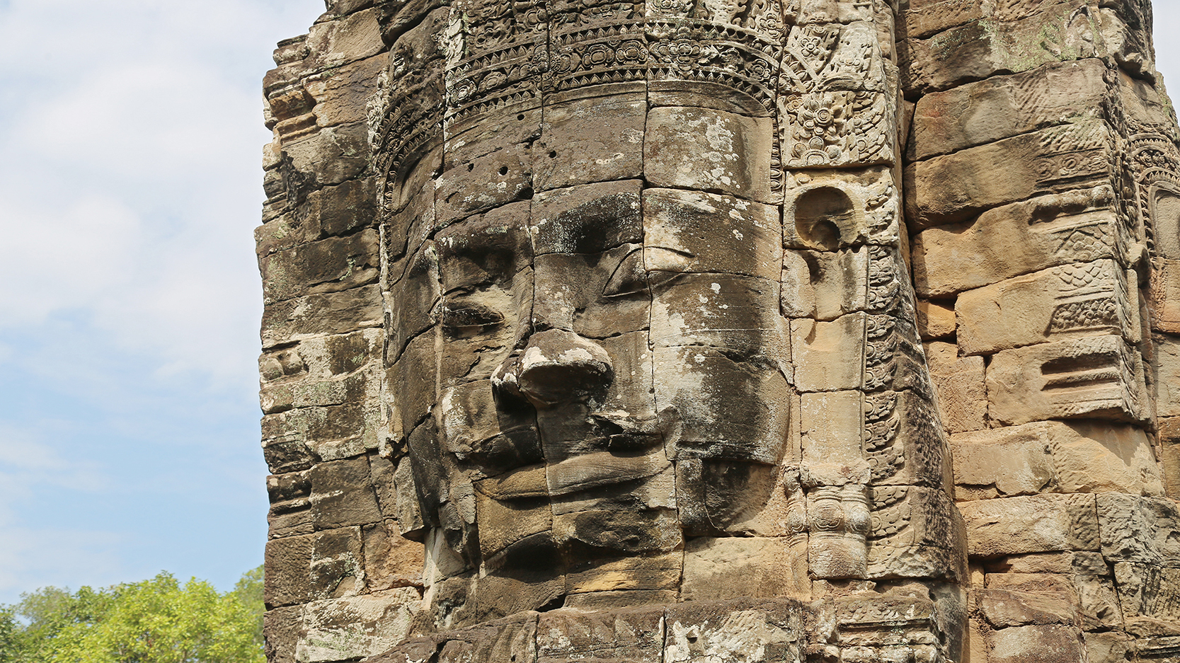 Reste einer Tempelanlage in Angkor mit einem in Stein gemeißelten Gesicht