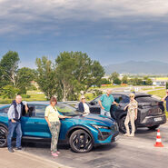 Teilnehmende des Programms "Mobil sein - mobil bleiben" posieren vor zwei Autos