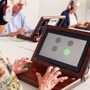 Eine Teilnehmerin macht an einem Tablet das freiwillige Reaktions- und Konzentrationstraining