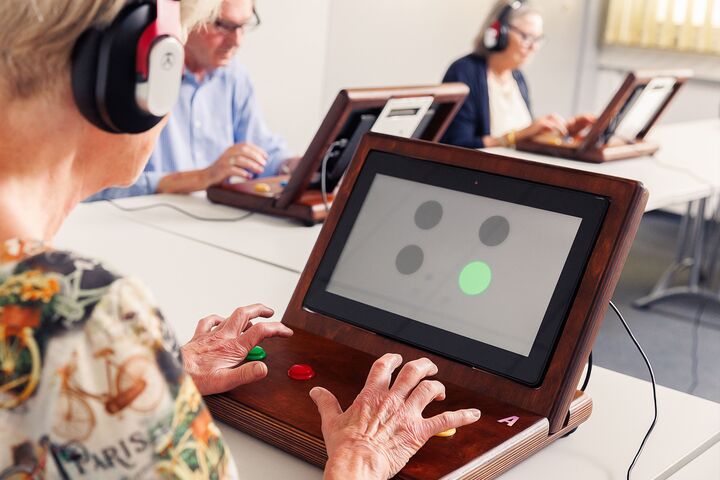 Eine Teilnehmerin macht an einem Tablet das freiwillige Reaktions- und Konzentrationstraining