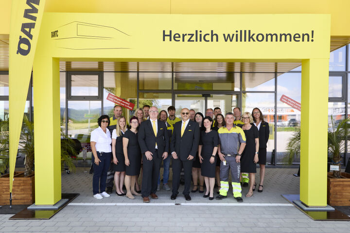 Gruppenfoto im Eingangsbereich des neuen Stützpunktes. Schriftzug: Herzlich willkommen!