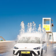 Ein weißer Pkw fährt durch ein Wasserhindernis in einem ÖAMTC Fahrtechnik Zentrum