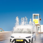Ein weißer Pkw fährt durch ein Wasserhindernis in einem ÖAMTC Fahrtechnik Zentrum